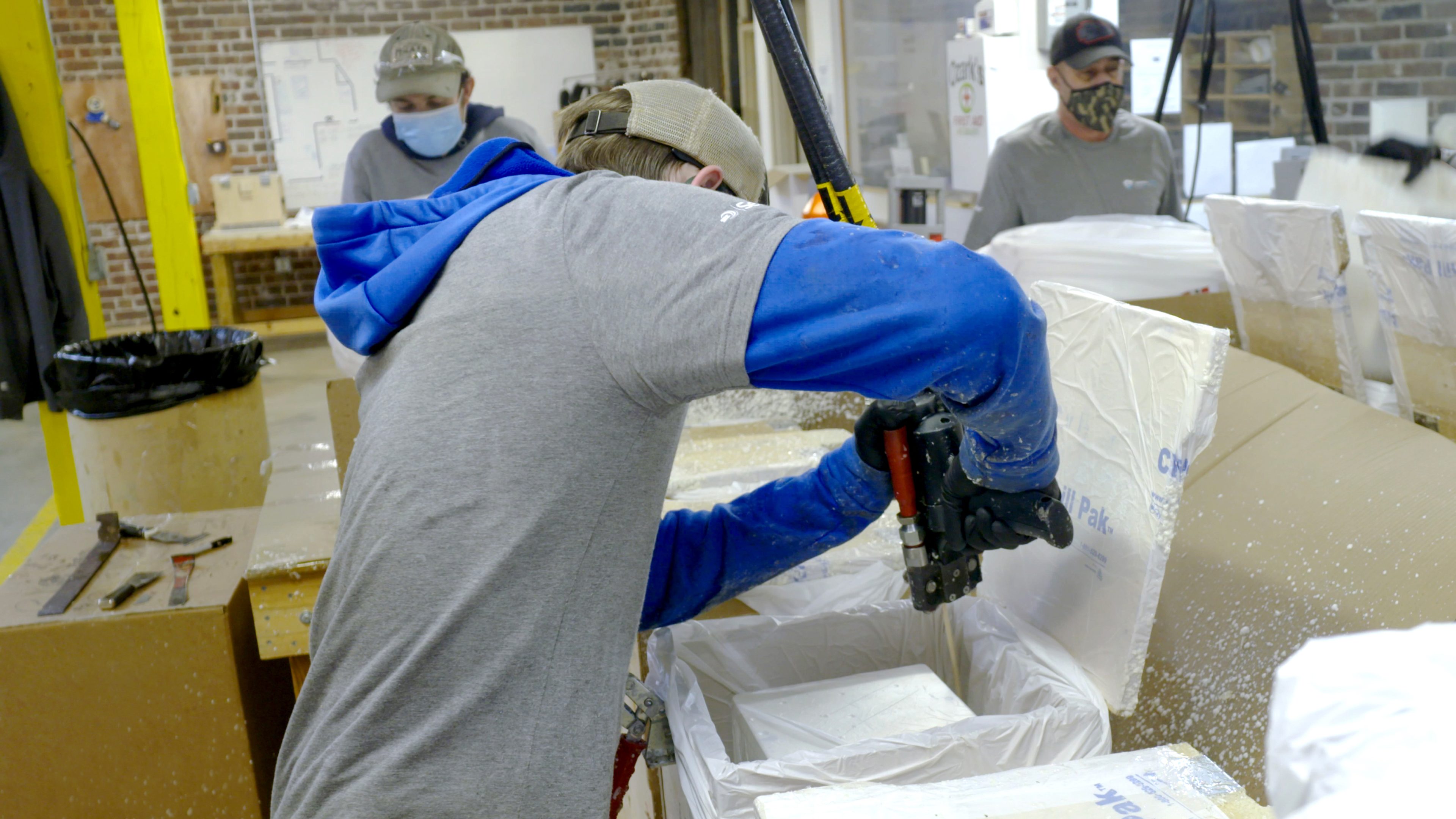 employé de ChillPak utilisant la mousse PUR de la marque SEALED AIR pour un conteneur de vaccins contre la Covid-19 