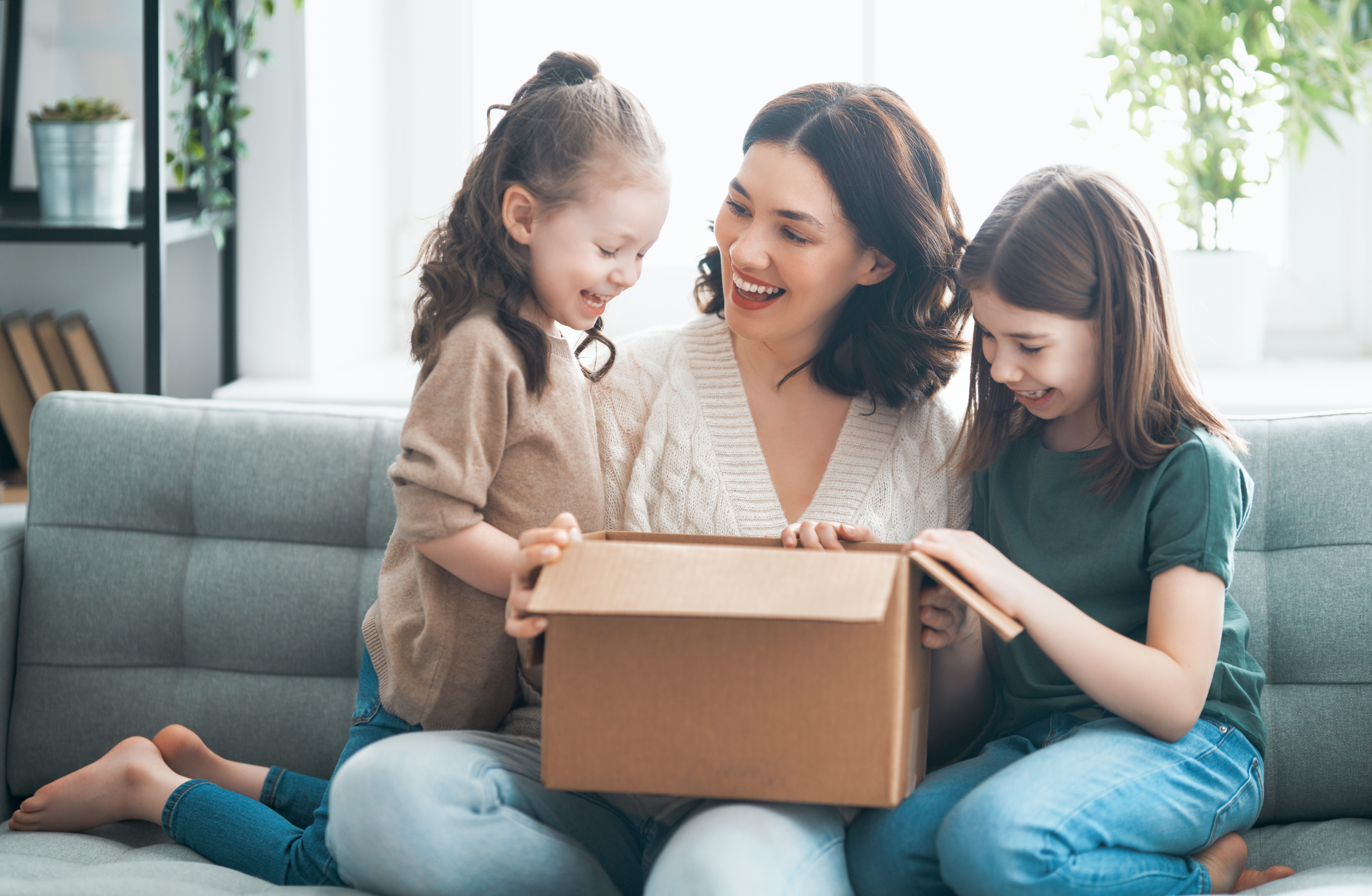 woman and two children opening a box